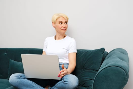 Senior woman was distracted during an online conversation while working at home