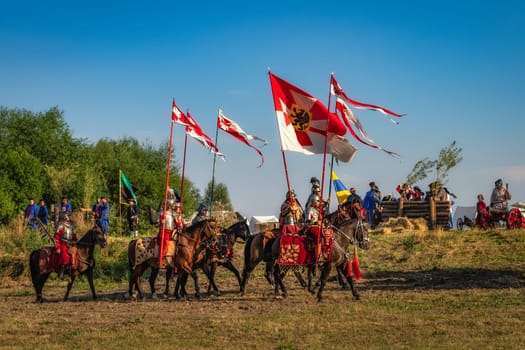 Gniew, Poland, Aug 2020 Polish hors cavalry, Hussars, riding on a battlefield with pendants and flags, historical reenactment of Battle of Gniew