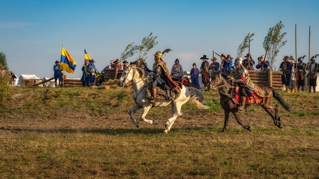 Gniew, Poland, Aug 2020 Horsman warriors, charging through a battlefield in front of fortifications, historical reenactment of Battle of Gniew