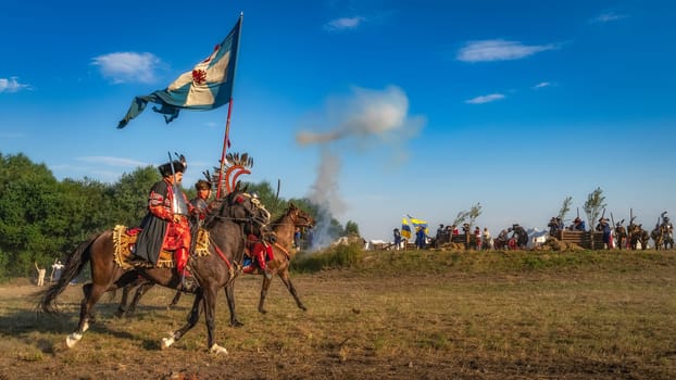 Gniew, Poland, Aug 2020 Polish heavy cavalry, Hussars, riding on a battlefield with pendants and flags, historical reenactment of Battle of Gniew