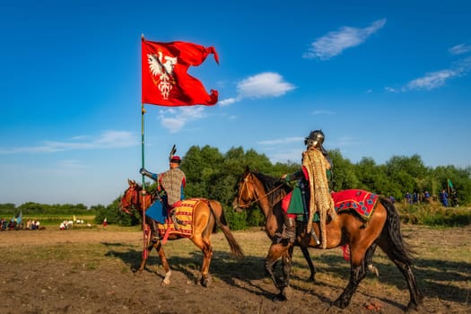 Gniew, Poland, Aug 2020 Polish hors cavalry, Hussars, riding with the flag, historical reenactment of Battle of Gniew