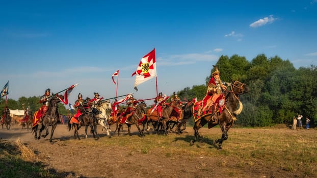 Gniew, Poland, Aug 2020 Castellan on a horse leading the charge of Hussars, polish cavalry, on enemy forces, historical reenactment of Battle of Gniew