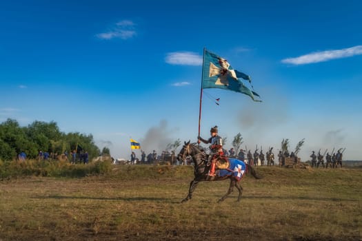 Gniew, Poland, Aug 2020 Horse rider with a flag riding through the battlefield, historical reenactment of Battle of Gniew from 16th century
