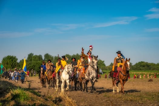 Gniew, Poland, Aug 2020 Polish hors cavalry, Hussars, riding and leading army column. Warrior waiving hand and greeting people. Historical reenactment