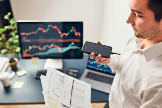 Businessman trading stocks online. Stock investor discussing numbers at graphs while phone conversation with his colleague. Business team planning and analyzing stock market graphs. Man working with stock chart data. Business man investing stock using online platform. Business success concept