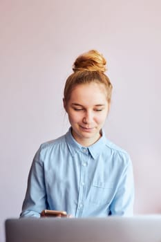 Young woman student having classes, learning online, watching lesson remotely, listening to professor, talking with classmates on video call from home during quarantine. Young girl using laptop sitting at a desk