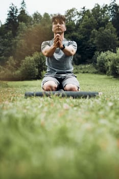 Young man doing exercises outside on grass during his calisthenics workout. Teenager training outdoors