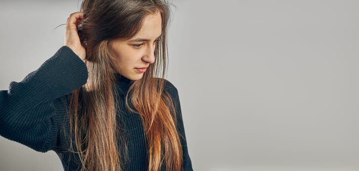 Portrait of young woman. Classic portrait in positive mood, beautiful model posing in studio over plain background looking at camera
