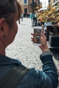 Young woman having video call talking while walking downtown in the evening wearing the face mask to avoid virus infection and to prevent the spread of disease in time of coronavirus