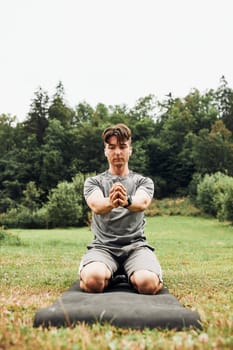 Young man doing exercises outside on grass during his calisthenics workout. Teenager training outdoors