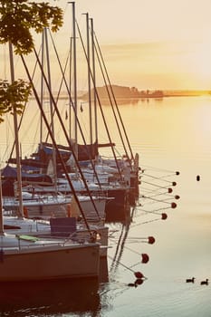 Yachts and boats moored in a harbour at sunrise. Candid people, real moments, authentic situations