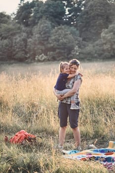 Family spending time together on a meadow, close to nature, parents and children playing together. Candid people, real moments, authentic situations
