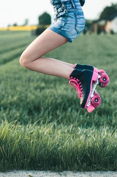 Teenage girl having fun rollerskating, jumping, spending time on summer day