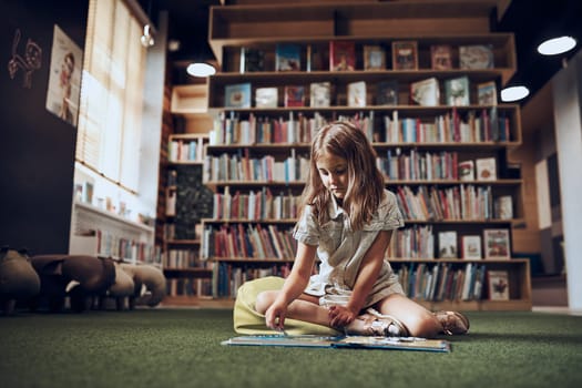 Child solving riddle in book in school library. Primary school pupil is involved in book with riddles. Smart girl learning to solve problems. Benefits of everyday practice. Child curiosity