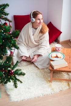 Young girl listening to Christmas carols through her headphones in the early morning