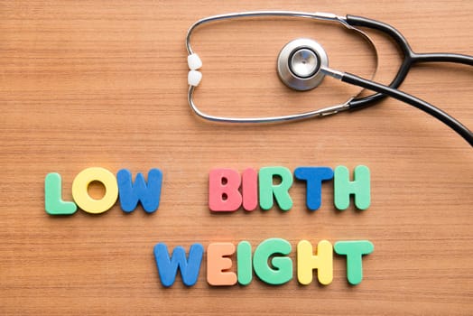 Low birth weight (LBW) colorful word with stethoscope on the wooden background