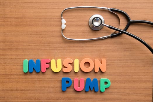 Infusion pump colorful word with stethoscope on the wooden background