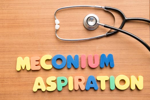 Meconium aspiration colorful word with stethoscope on the wooden background