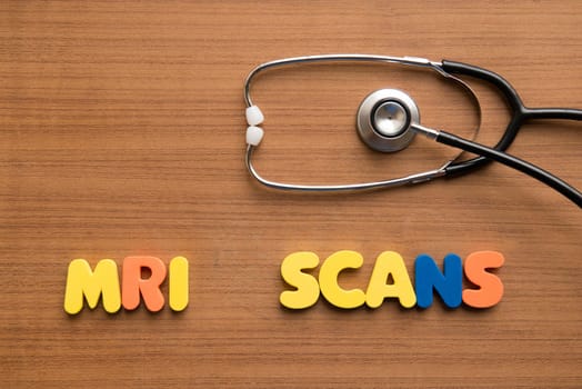 MRI scans colorful word with stethoscope on the wooden background