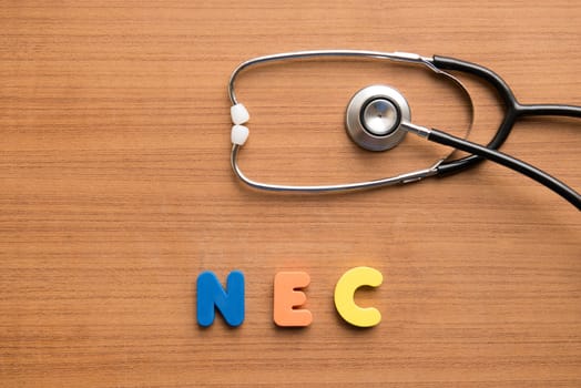 Necrotising enterocolitis (NEC) colorful word with stethoscope on the wooden background