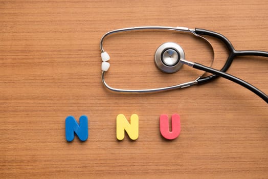 NNU colorful word with stethoscope on the wooden background