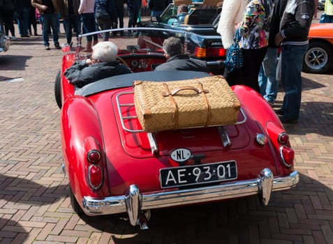 vintage red oldtimer car during the 14th orange tour. This annual tour takes places during the king's birthday celebrations, a national holiday.