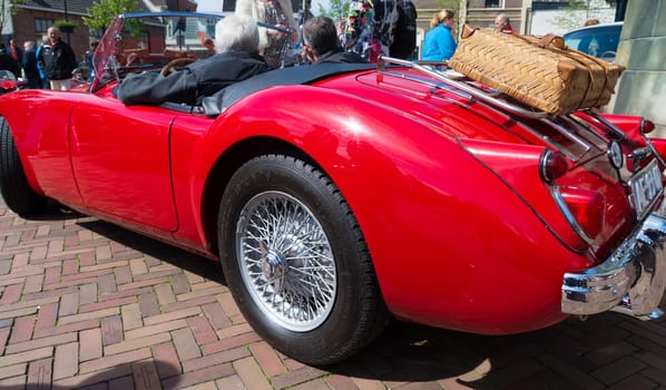 vintage red oldtimer car during the 14th orange tour. This annual tour takes places during the king's birthday celebrations, a national holiday.