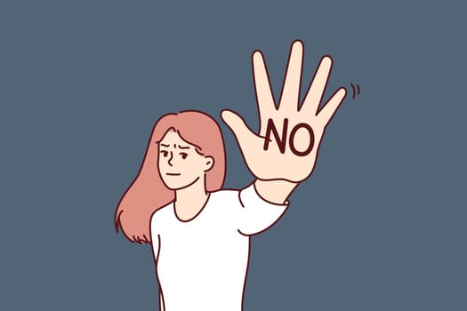 Brave woman makes stop gesture showing palm with inscription no to call for end to violence or discrimination. Woman feminist expresses denial and fights against discrimination or harassment