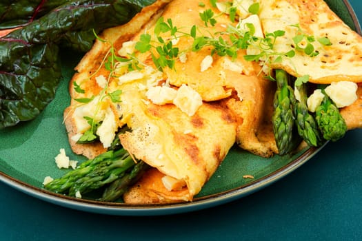 Egg omelet stuffed with green asparagus, cheese and herbs.