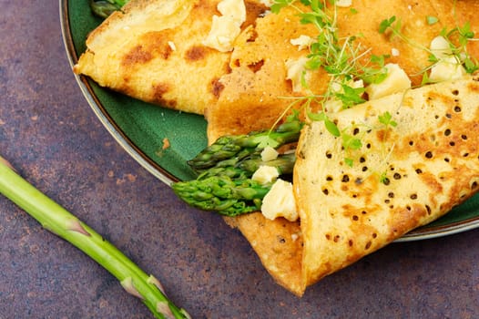 Egg omelet stuffed with green asparagus, cheese and herbs.