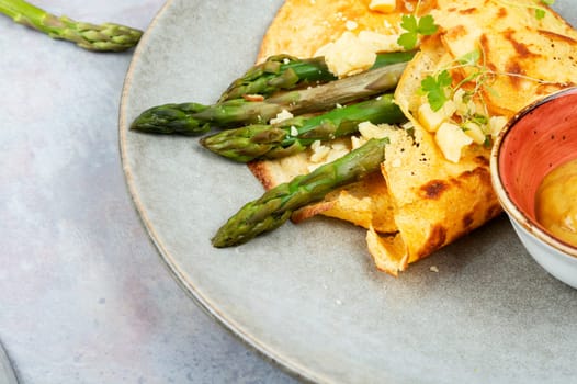 Egg omelet stuffed with green asparagus, cheese and herbs.