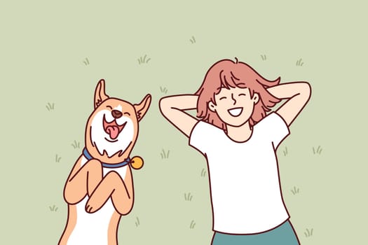 Little girl and dog lie on grass in backyard of house and enjoy sunny summer day. Laughing teenage girl with red dog shiba inu relaxing on lawn enjoying local pastime during vacation