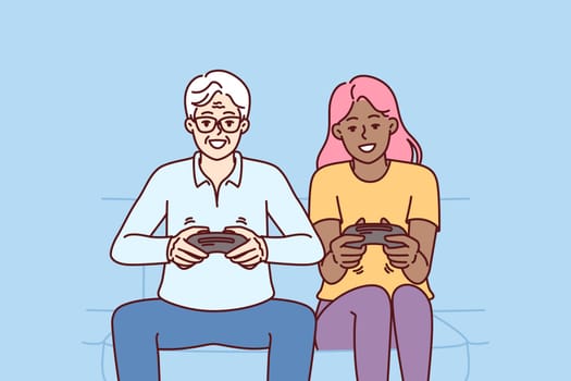 Diverse man and woman with joysticks are sitting on sofa playing game fighting virtual characters. Elderly human and African American girl play multiplayer console game spending weekend together