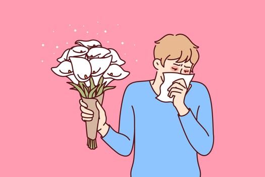 Allergic man holding bouquet flowers and using handkerchief suffering from pollen in need of allergy medicine. Everyday guy allergic with lilies wanting to make romantic gift suffers from runny nose