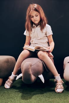 Schoolgirl reading book in school library. Smart girl learning from book. Child doing homework. Primary school pupil preparing for next class. Benefits of everyday reading. Child curiosity