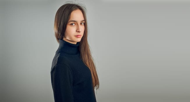Portrait of young woman. Classic portrait in positive mood, beautiful model posing in studio over plain background looking at camera