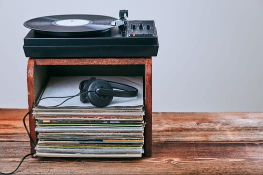 Stack of black vinyl records, turntable vinyl player and headphones. Classic stereo set. Candid people, real moments, authentic situations