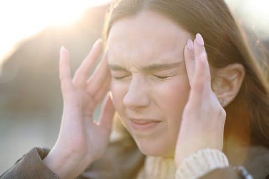 Close up of a woman suffering head ache outdoors and complaining