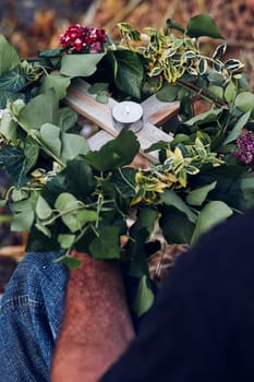 Wreaths of flowers and herbs. Man taking a wreath from a river. Midsummer divination
