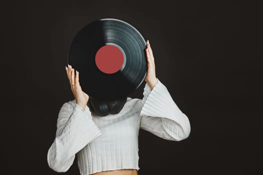 Woman holding vinyl record. Music passion. Listening to music from analog record. Playing music from analog disk on turntable player. Enjoying music from old collection. Retro and vintage. Stereo audio. Analog sound