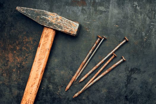 Hammer and nails on steel surface. Tools for maintenance. Hardware tools to fix. Technical background with copy space