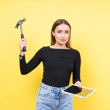 Service center. Laptop Repair. Female screwdriver unscrews laptop bolts on a yellow background