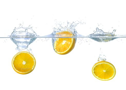 Oranges fall into the water with splashes
