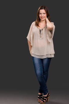 Beautiful young woman posing in a grey background
