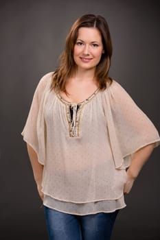 Beautiful young woman posing in a grey background