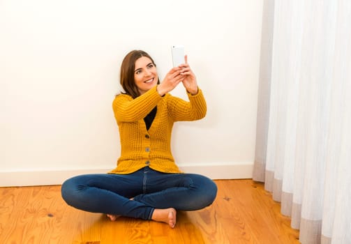 Gorgeous young woman at home texting and laughing