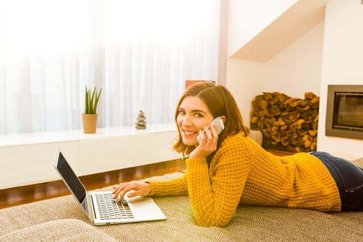 Gorgeous young woman at home texting and laughing
