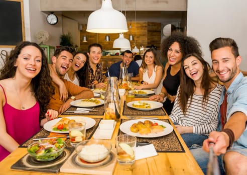 Multi-Ethnic Group of happy friends lunching and having fun at the restaurant
