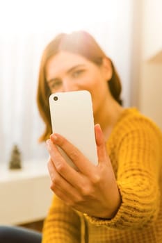Gorgeous young woman at home texting and laughing