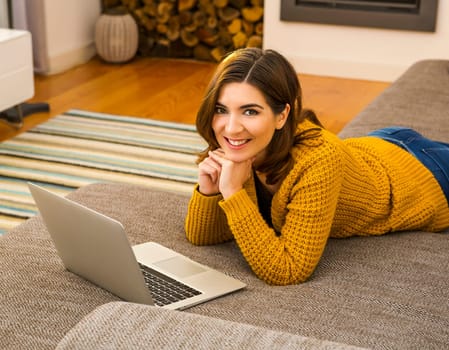 Beautiful woman working from the confort of home with her laptop